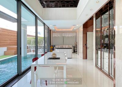 Modern dining area with adjacent living room and pool view