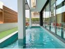 Outdoor pool area with greenery and patio seating