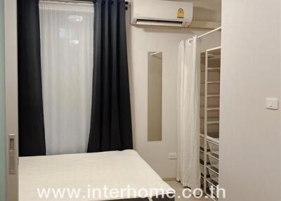 Modern bedroom with bed, curtains, air conditioner, and wardrobe