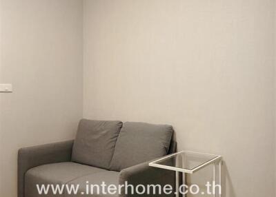 Small living room with a grey sofa and side table