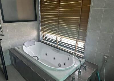 Modern bathroom with large soaking tub and window blinds