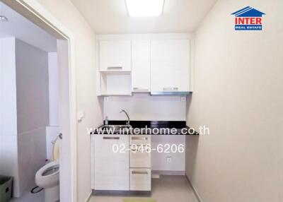 Small kitchen area with white cabinets