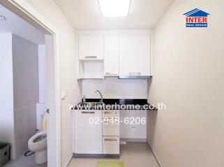 Small kitchen area with white cabinets