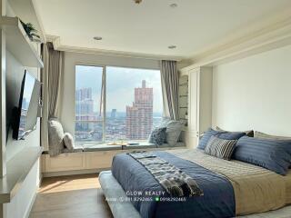 Spacious bedroom with a city view, large bed, and built-in storage