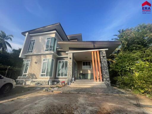 Modern two-story house with large windows and driveway