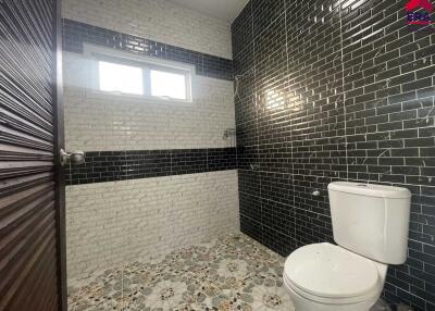 Modern bathroom with dark tiles and patterned flooring