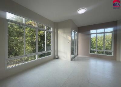 Spacious living room with large windows offering a view of greenery