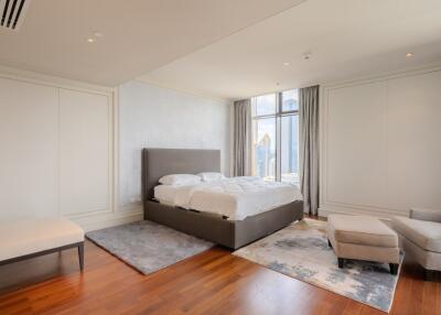 Modern bedroom with a large bed, wooden flooring and panoramic window