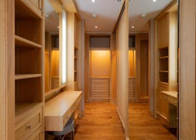 Spacious walk-in closet with built-in wooden shelves and vanity