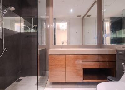 Modern bathroom with wooden vanity and glass shower enclosure