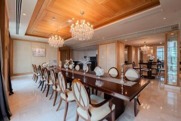 Elegant dining room with a long wooden table, chandelier lighting, and decorative elements