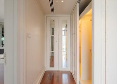 Modern hallway with mirrored wardrobe and wood flooring