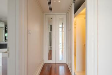 Modern hallway with mirrored wardrobe and wood flooring