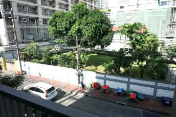 View from the balcony overlooking a street and a green area