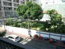 View from the balcony overlooking a street and a green area