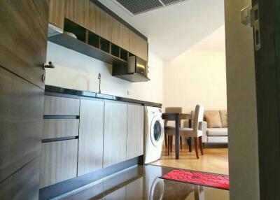 Modern kitchen with wooden cabinetry and adjacent dining area