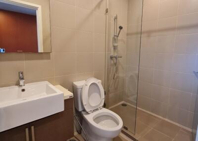 Modern bathroom with glass shower, toilet, and sink