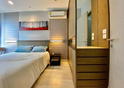 Modern bedroom with bed, air conditioning, and wooden furniture