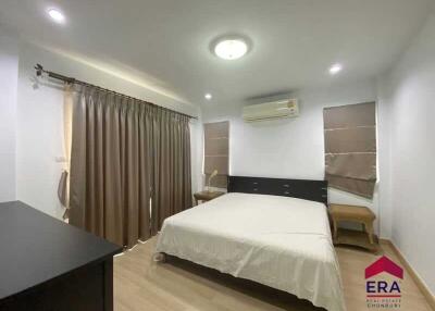 Spacious bedroom with a large bed, air conditioning, and natural light from windows