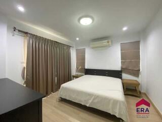 Spacious bedroom with a large bed, air conditioning, and natural light from windows