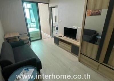 Living room with sofa, coffee table, TV, and large window