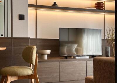 Modern living room with TV, shelving, and accent chair