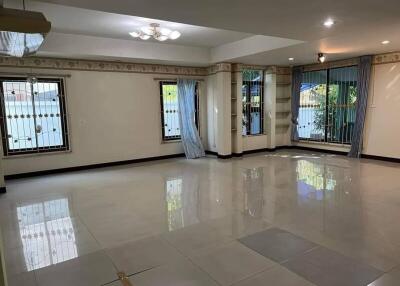 Spacious and well-lit living room with tiled floors and multiple windows