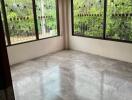 Empty bedroom with tiled floor and large windows