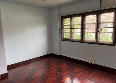 Empty bedroom with windows and hardwood flooring