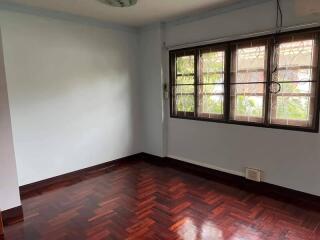 Empty bedroom with windows and hardwood flooring