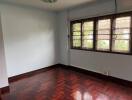 Empty bedroom with windows and hardwood flooring