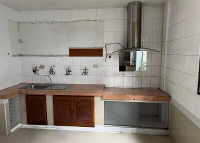 Partially furnished kitchen with countertop and exhaust system