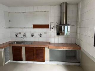 Partially furnished kitchen with countertop and exhaust system