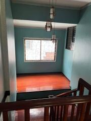 View of a staircase landing with wooden railings and large window