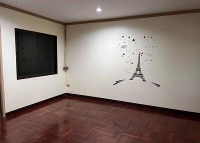 Empty bedroom with wall art and wooden floor