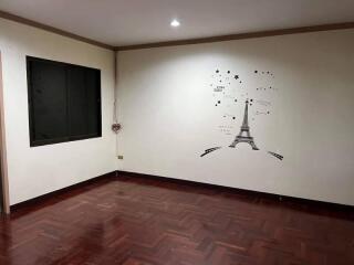 Empty bedroom with wall art and wooden floor