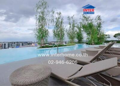 Luxury outdoor swimming pool with lounge chairs and city view