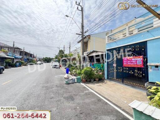 Street view of the property with gated entrance and potted plants