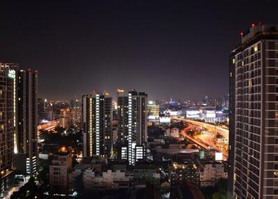 Night view of a cityscape from a high vantage point with tall buildings and illuminated streets