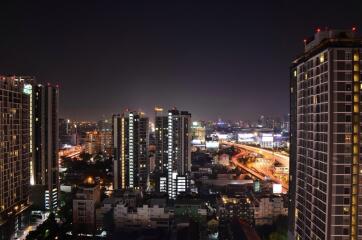 Night view of a cityscape from a high vantage point with tall buildings and illuminated streets