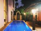 Outdoor swimming pool at night with lit surroundings