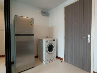 Utility room with a refrigerator and washing machine