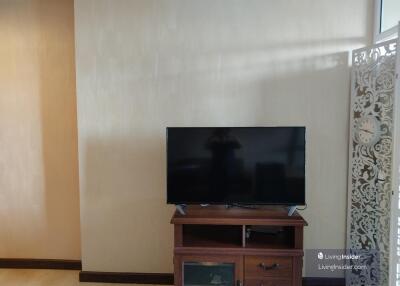 Living room with TV on a wooden cabinet and decorative screen wall