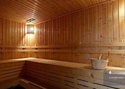 Wooden sauna with seating and bucket