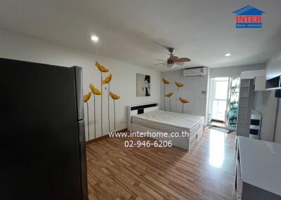 Bedroom with wooden flooring, bed, wardrobe, and wall art