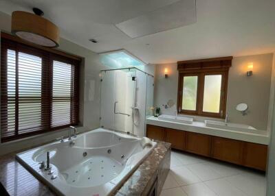 Spacious bathroom with double vanity, bathtub, and glass shower