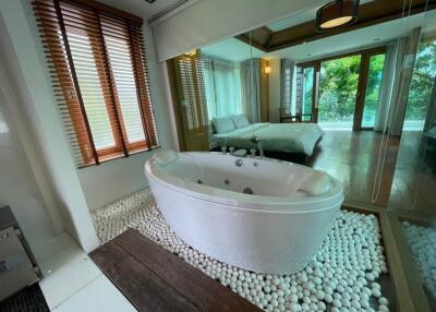 Spacious bedroom with an en-suite bathtub and panoramic window views