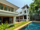 Exterior view of a modern multi-story home with pool and garden