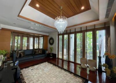 Spacious living room with large windows and chandelier