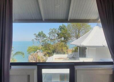 View through window showing outdoor scenery with ocean and trees